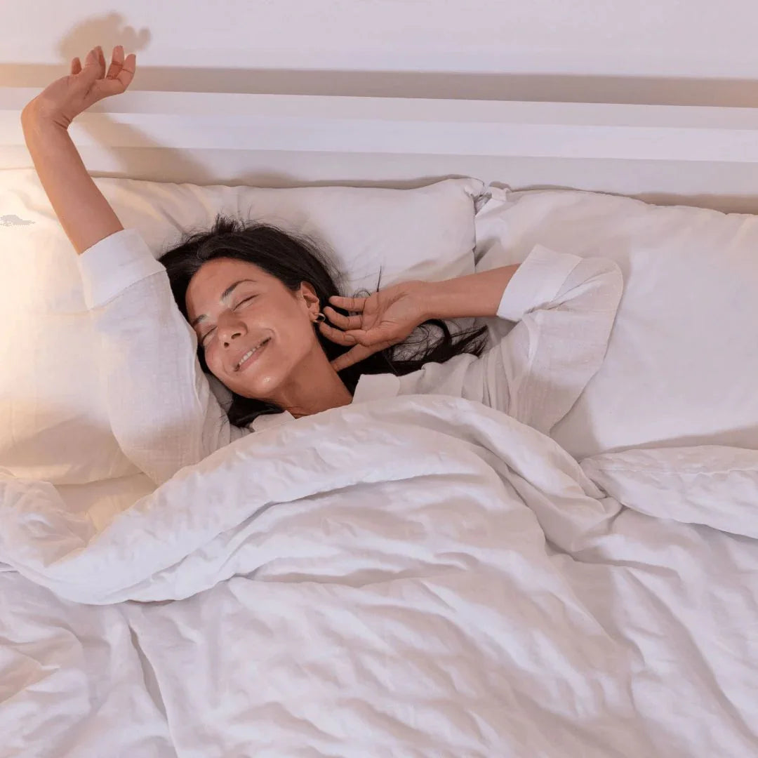白い布団でリラックスして目覚める女性、快適な寝具と快眠のイメージ